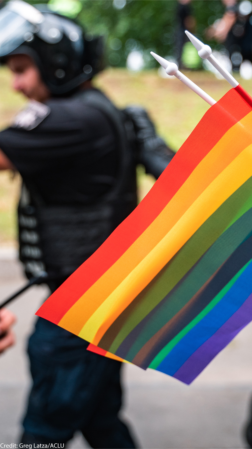LGBTQ flag with police in the background.