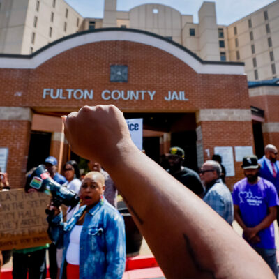 Protester with raised fist in the air at Fulton County Jail after the death of Lashawn Thompson.