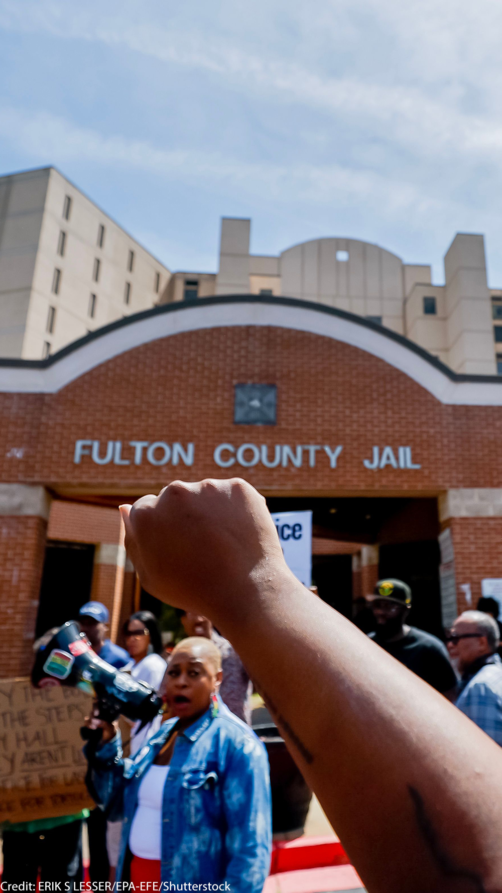 Protester with raised fist in the air at Fulton County Jail after the death of Lashawn Thompson.