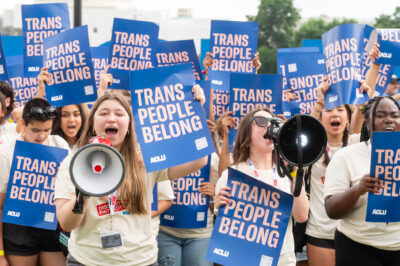 A group of young demonstrators holding ACLU signs that say Trans People Belong.