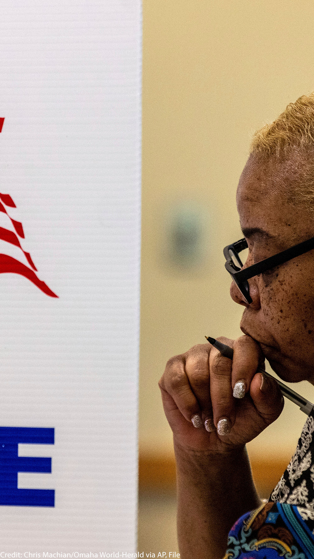 A profile view of a woman in a voting booth.