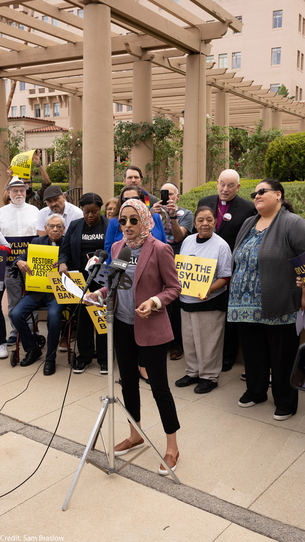 A woman speaking at a rally for asylum.