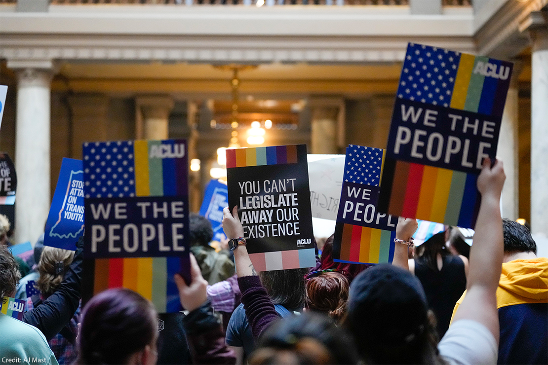 ACLU Supporters carrying signs with the ACLU logo reading" We The People."