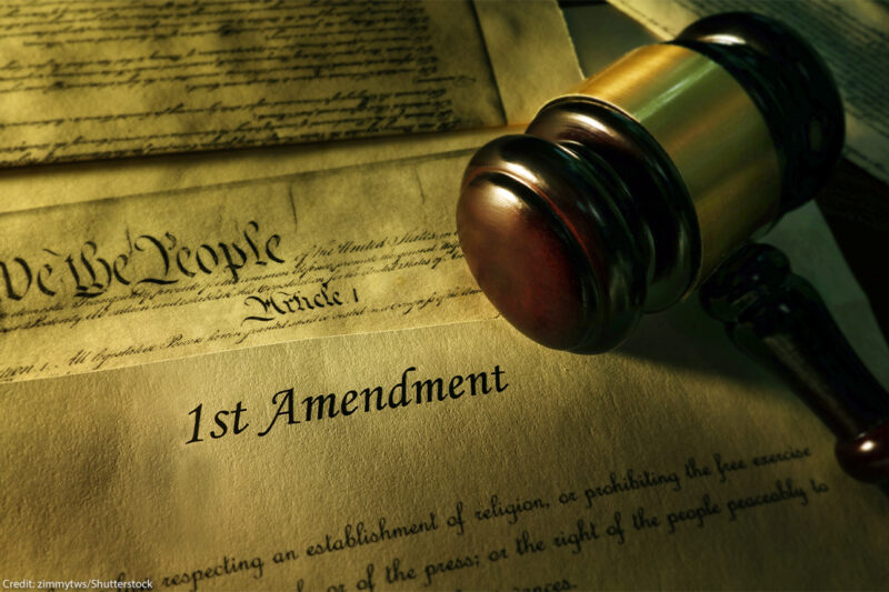 Court gavel resting atop the US Constitution document, where First Amendment starts.