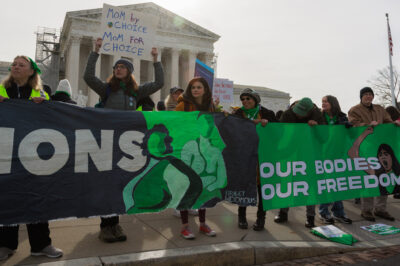 A group of demonstrators holding a banner saying "Our Bodies, Our Freedom."