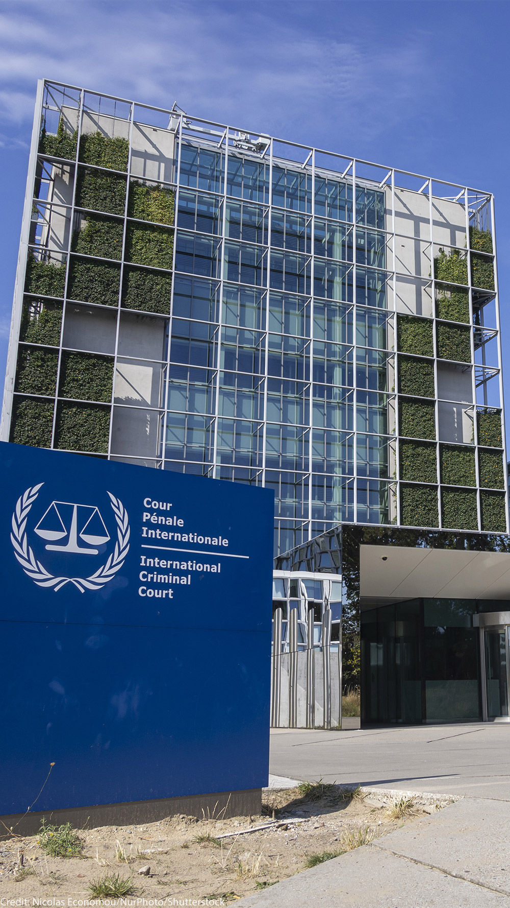 An exterior view of the International Criminal Court In The Hague, Netherlands, with the sign of with of the official logo and inscription of the International Criminal Court in the foreground.