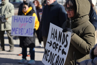 Demonstrators holding signs that read "HANDS OFF MEDICAID" protest the Trump administration's plan to roll back Medicaid expansion during a rally in front of the DuPage County Court House in Illinois.
