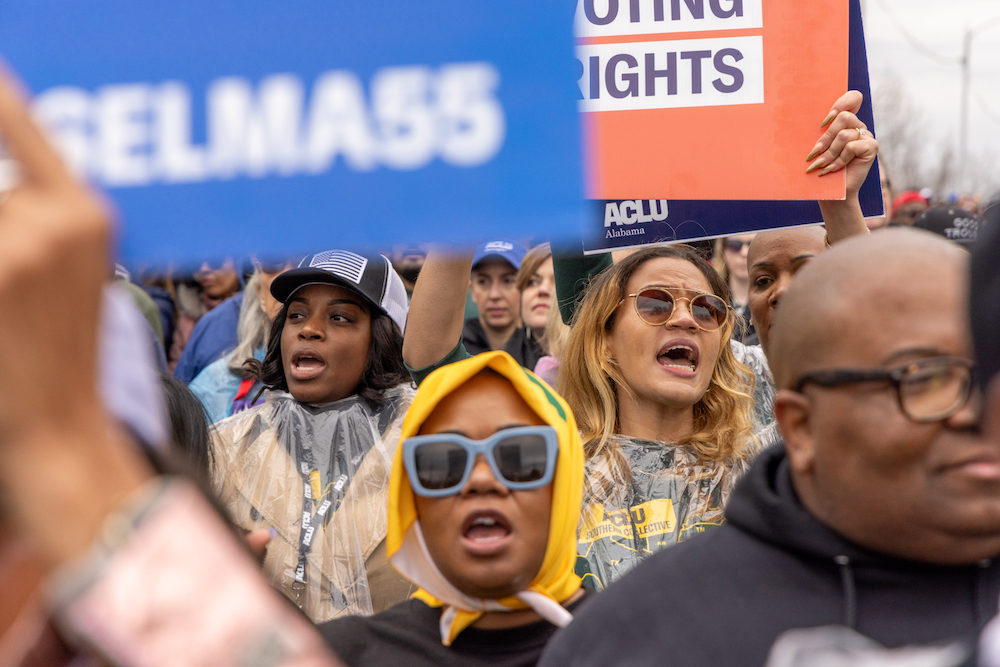 A group of voting rights advocates marching over the Edmund Pettus Bridge.