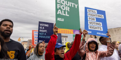 A group of voting rights advocates marching over the Edmund Pettus Bridge.