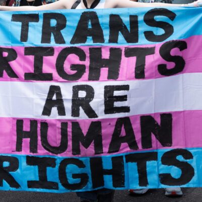 Trans Rights, speakers, protesters, and supporters denounce the Trump Administration's persistent attacks on the transgender community. by carrying a huge sign reading" TRANS RIGHTS ARE HUMAN RIGHTS".