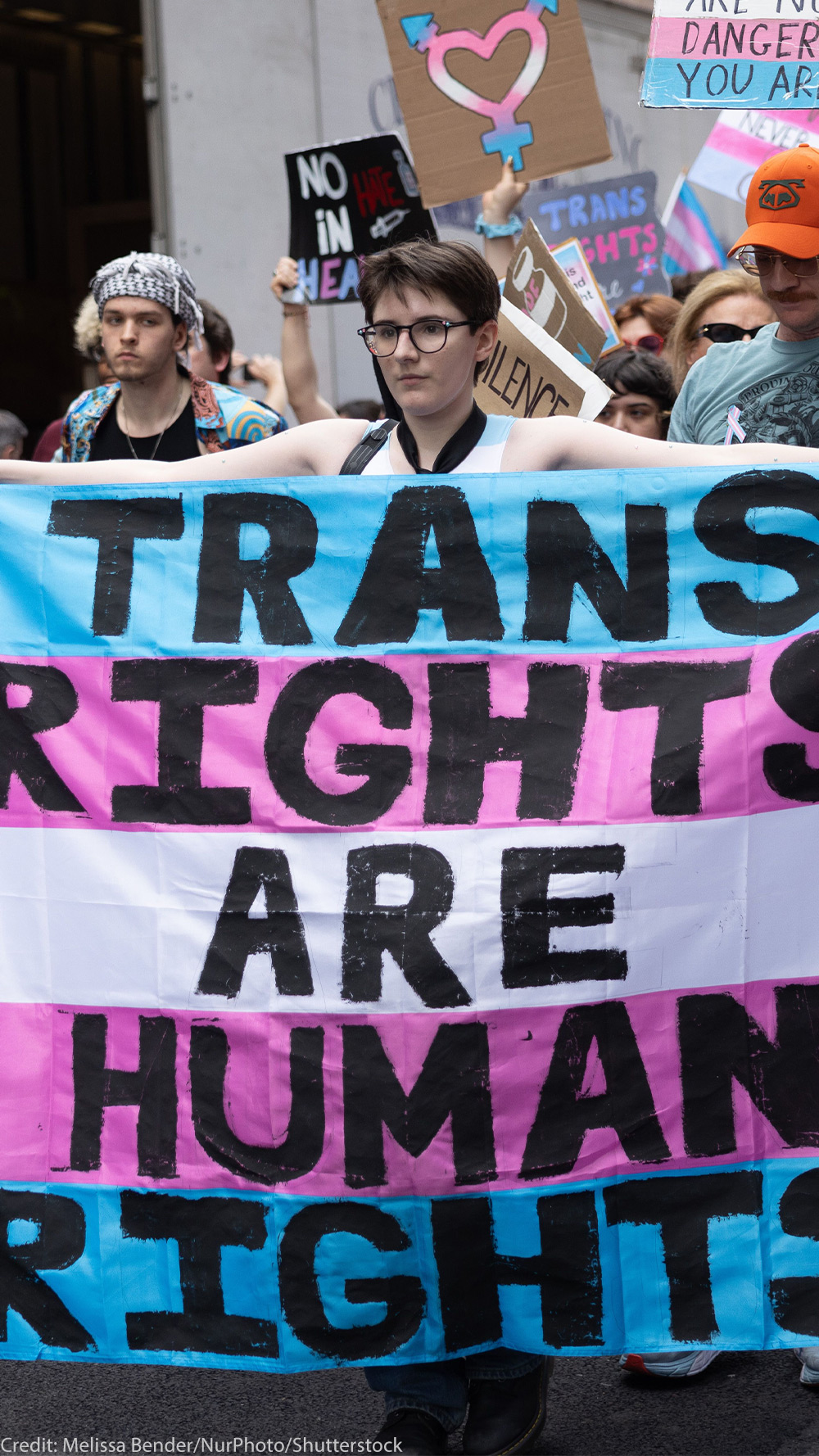 Trans Rights, speakers, protesters, and supporters denounce the Trump Administration's persistent attacks on the transgender community. by carrying a huge sign reading" TRANS RIGHTS ARE HUMAN RIGHTS".