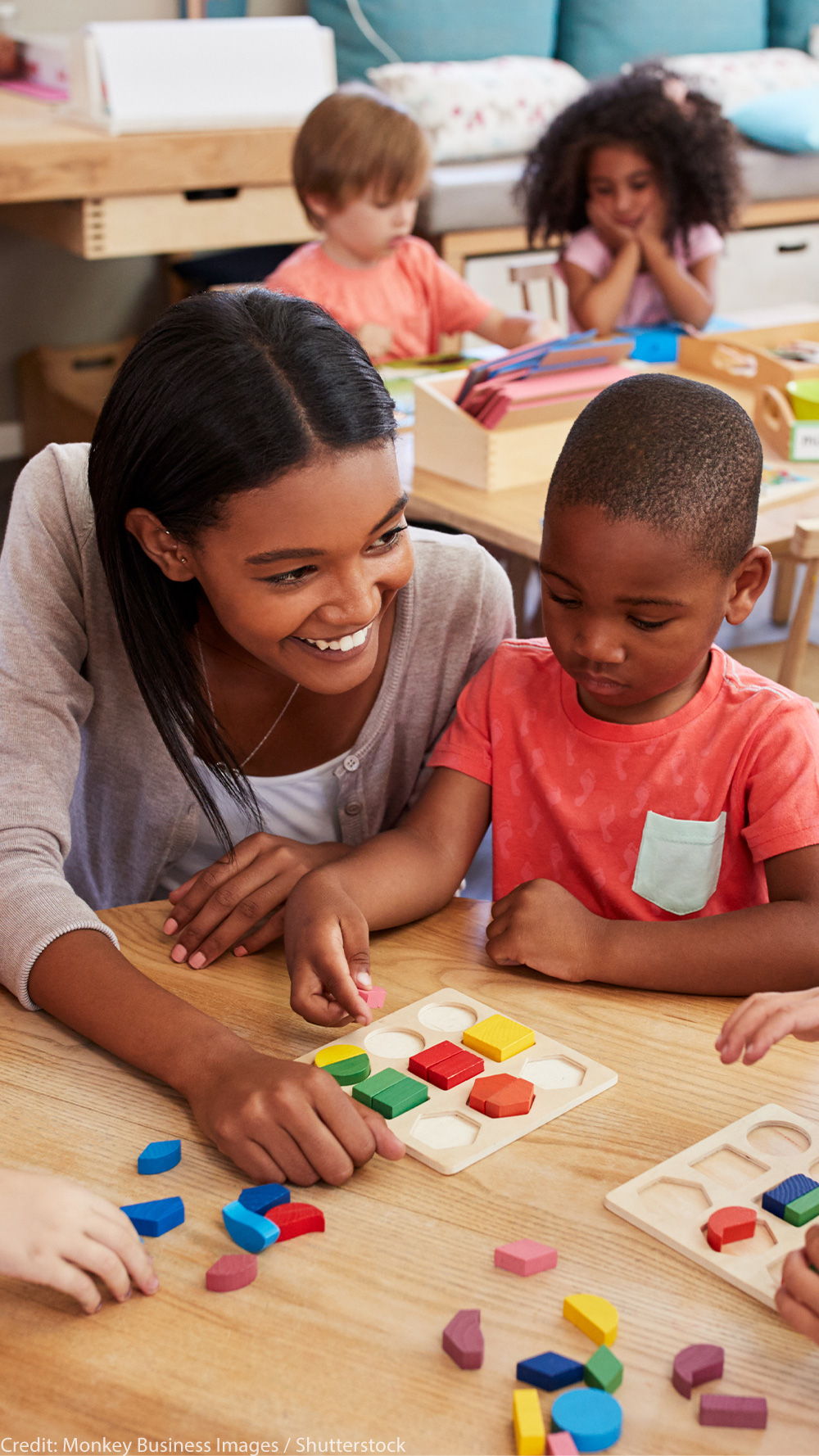 Teacher and pre-K students using wooden shapes.
