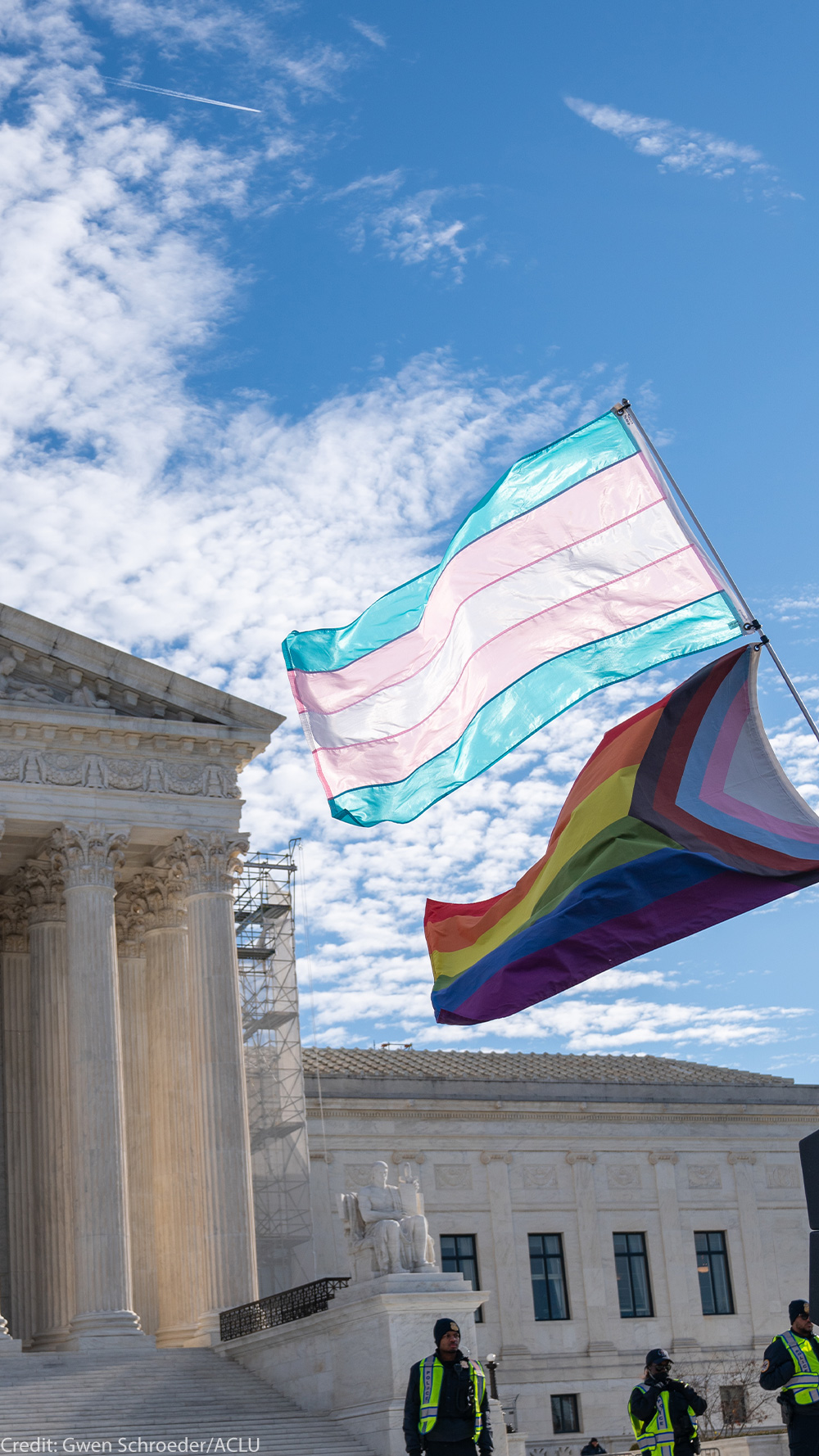 The Trans and LGBTQ+ flags waving in the wind in front of the Supreme Court Building in DC.