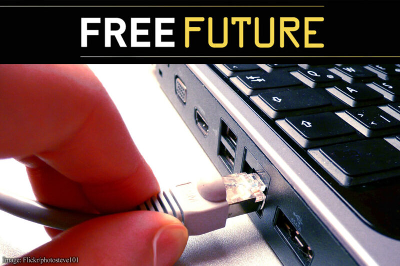 Two fingers disconnecting a network cable from a computer