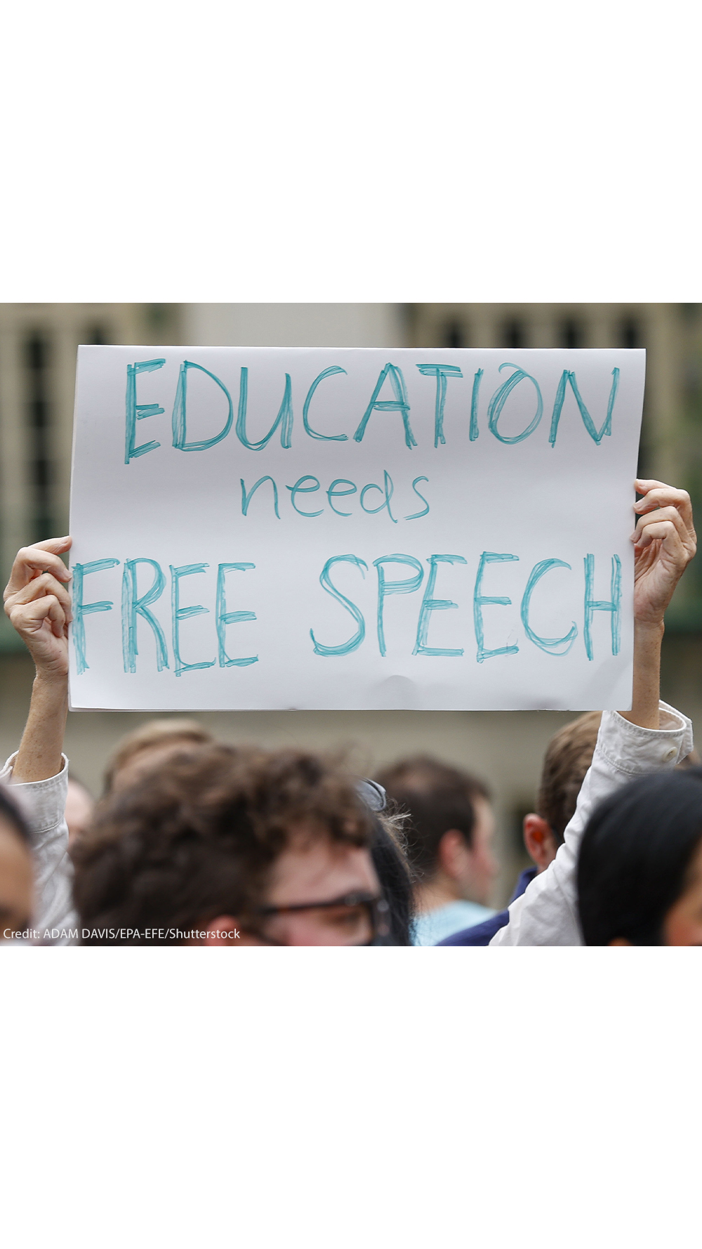 A student holds up a placard reading 'Education needs free speech' while attending a march.