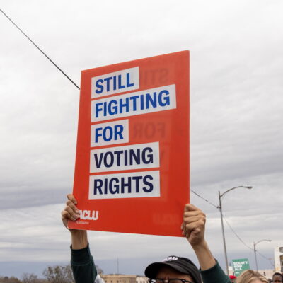 A sign which reads "Still Fighting for Voting Rights"