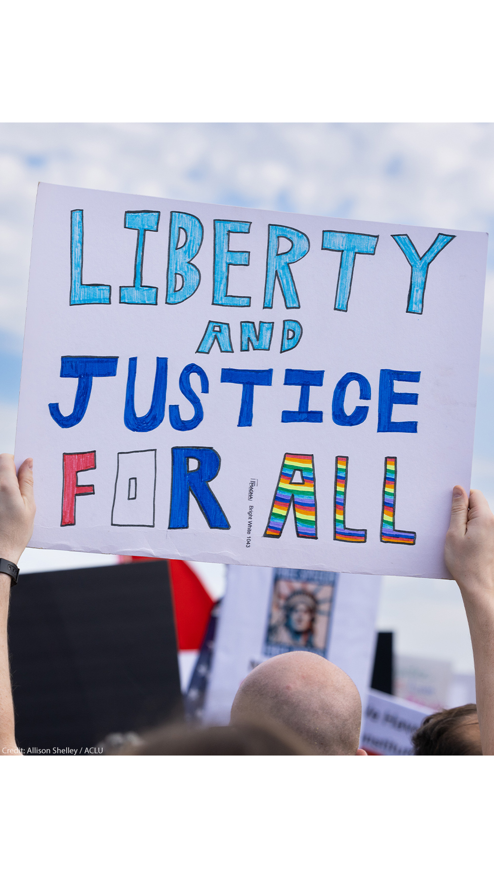 A demonstrator holds up a sign that reads, "LIBERTY AND JUSTICE FOR ALL" at the No Kings National Day of Action protest near the U.S. Capitol building in Washington, D.C., October 18, 2025.