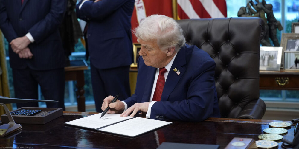 President Trump signs an executive order in the Oval Office of the White House.