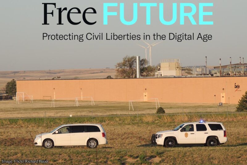 A police car behind a car it has pulled over alongside a highway