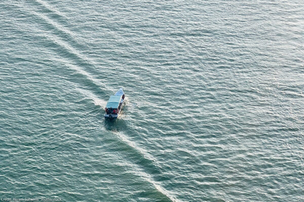 High-angle aerial shot of a small motorboat.